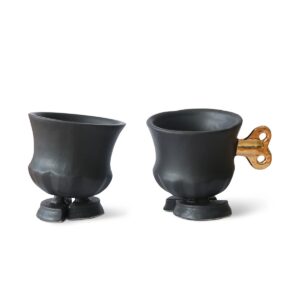 Een abstract kunstwerk van Jasmin Djerzic, genaamd "Robucups", met een matzwarte afwerking. Het object combineert functionaliteit met fantasie en toont een moderne, speelse uitstraling.